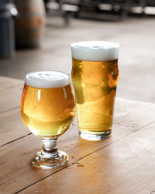 Two golden beers with thick foam crowns on a wooden table